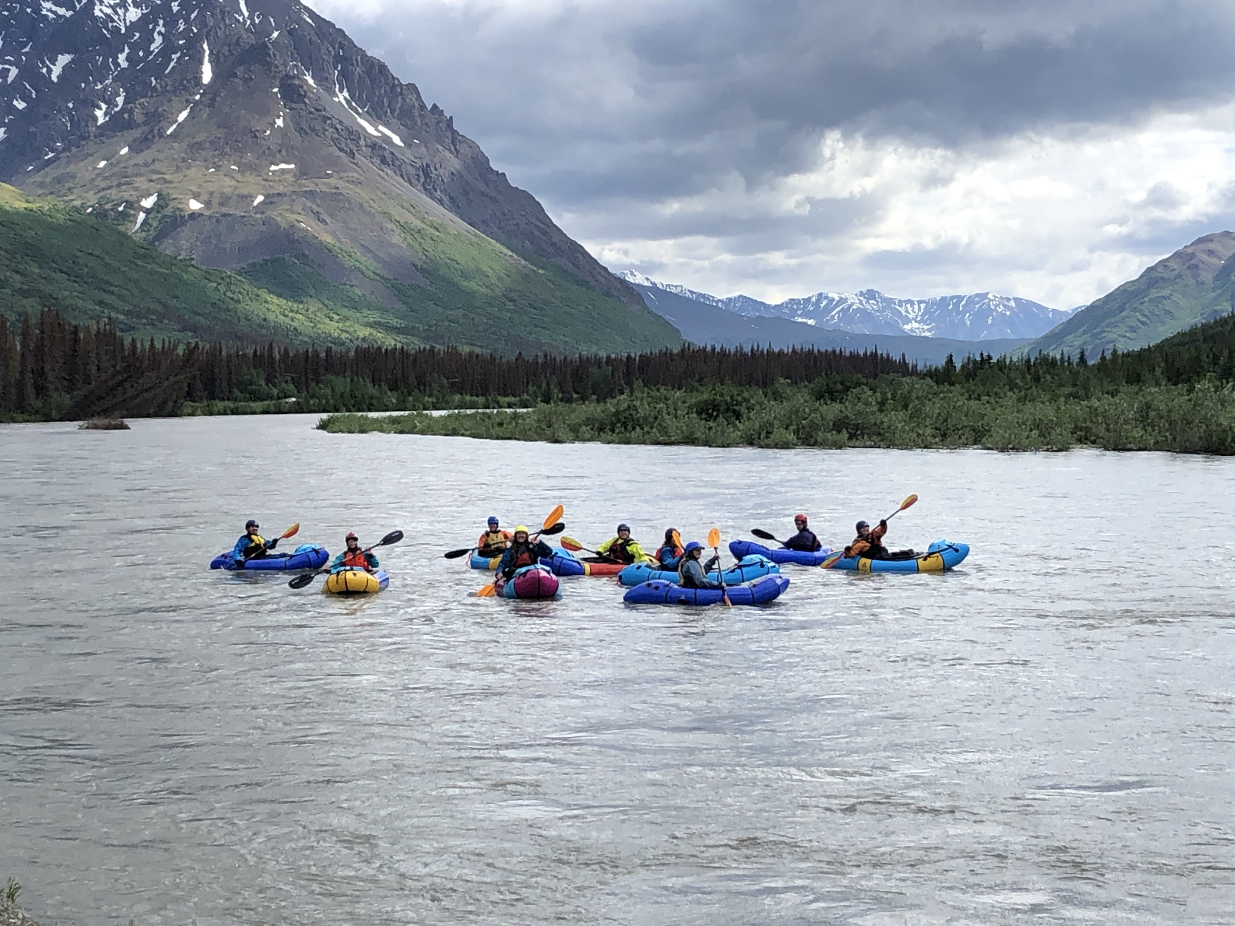 9 packrafters on a wide, flat section of the Nenana River posing for a group photo